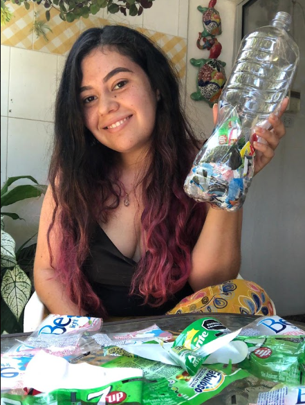 Joven mostrando un ecoladrillo elaborado con residuos plásticos