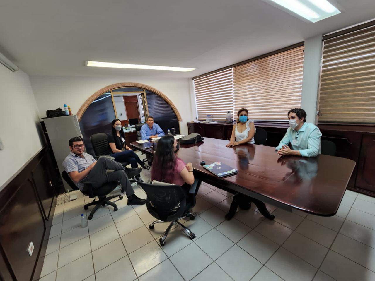 Personas adultas reunidas alrededor de una mesa de trabajo