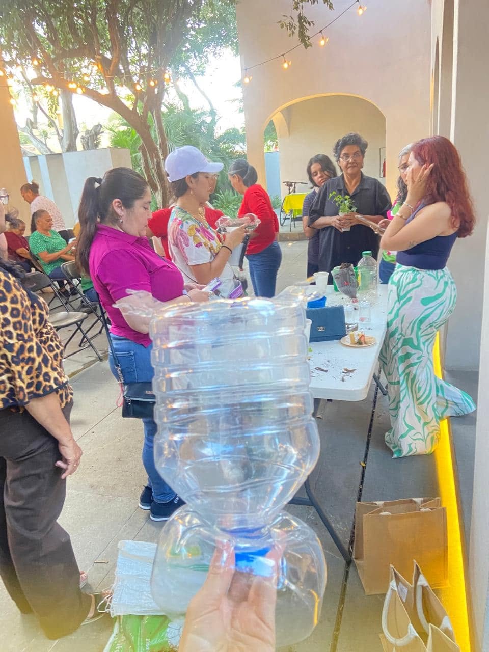 Participantes aprendiendo a reutilizar botellas durante un taller